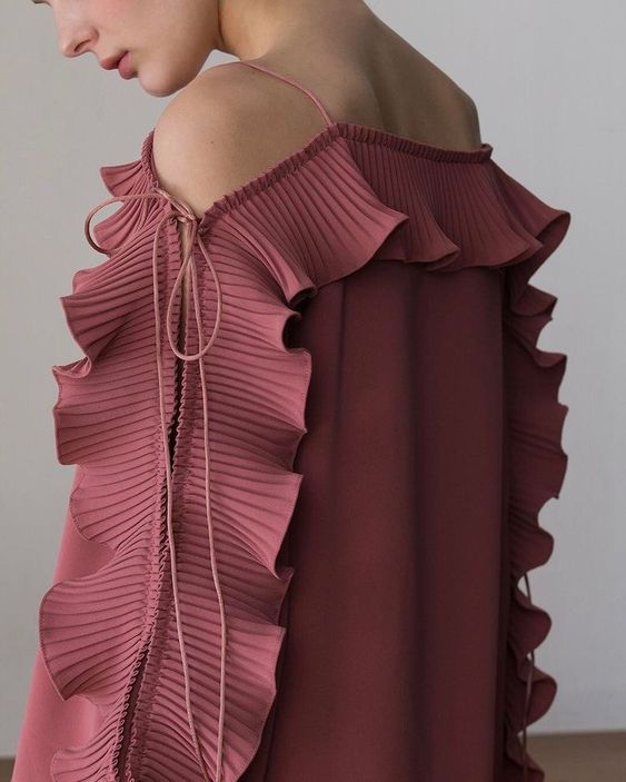 Robe rose ouverte au niveau des épaules avec volants sur les manches